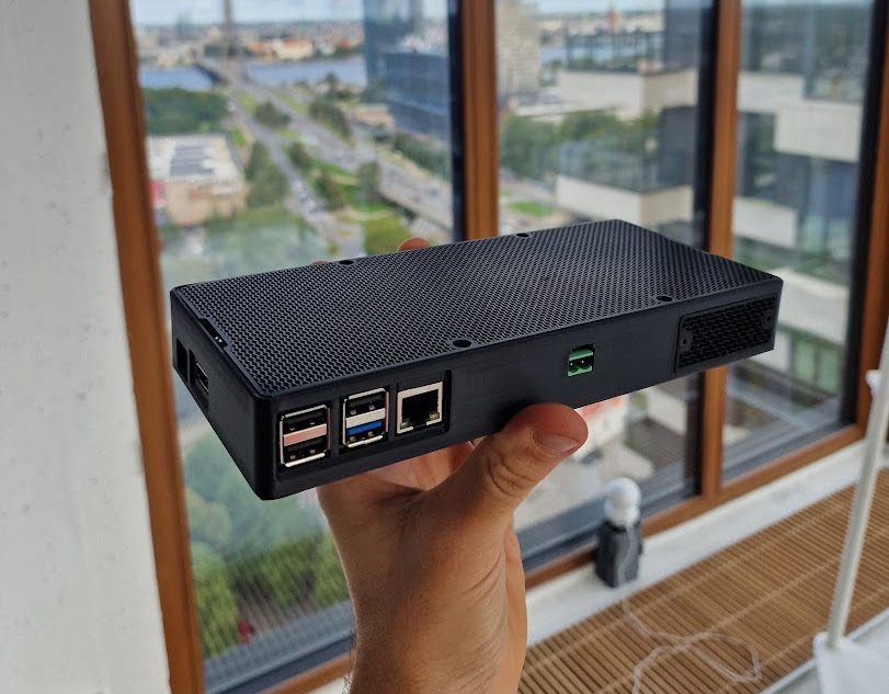 Compact AI booster held in one hand, showing its USB and network ports